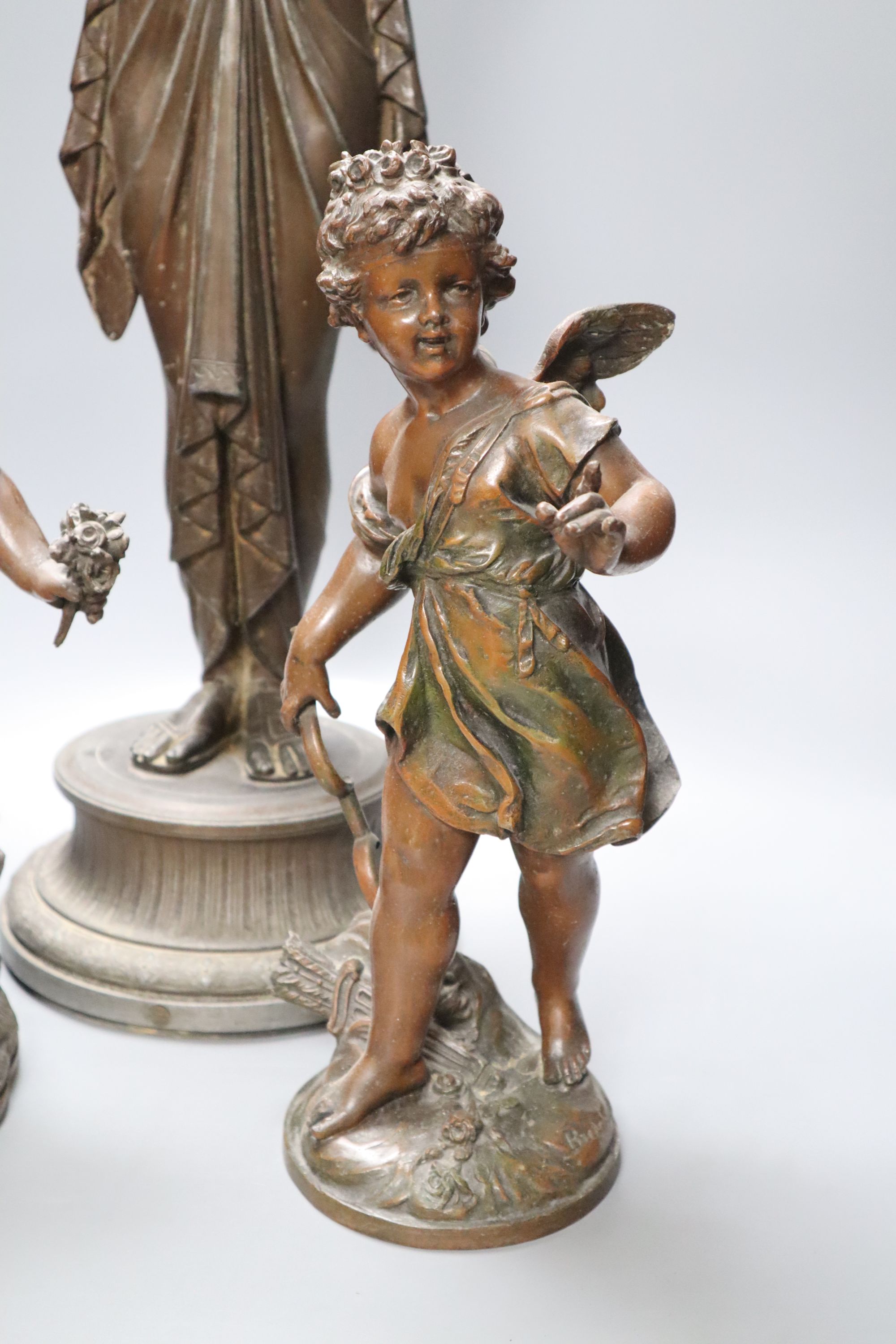 A pair of spelter cherubs, after Bruchon, and another spelter figure, height 74cm